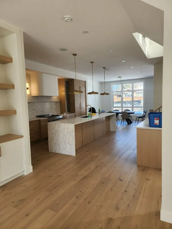 Open-plan kitchen with marble island and floating shelves