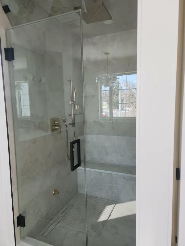 Frameless glass shower with bench and window