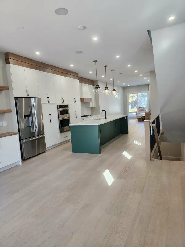 White kitchen with green island and stainless steel appliances