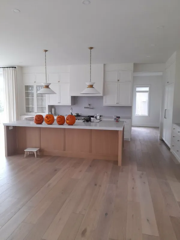 White kitchen renovation with wood island and pendant lights