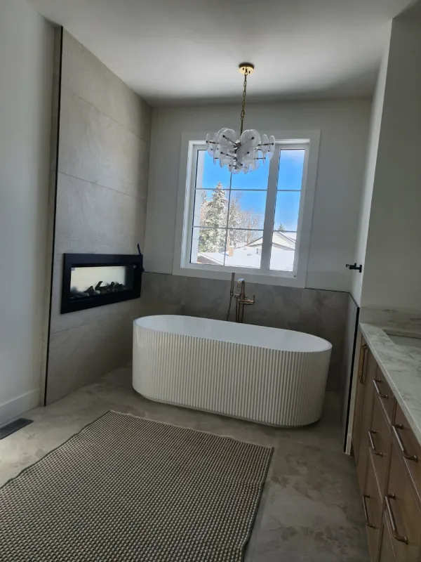 Master bathroom with fluted freestanding tub beside a fireplace