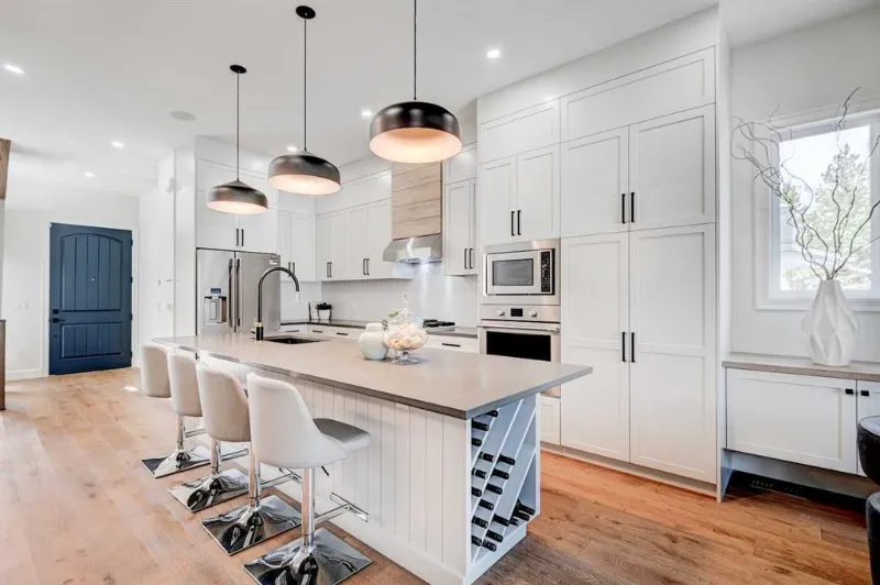 White kitchen renovation with large island and pendant lights